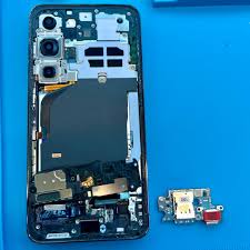 Professional phone repair technician inspecting Samsung Galaxy phone in NYC repair shop